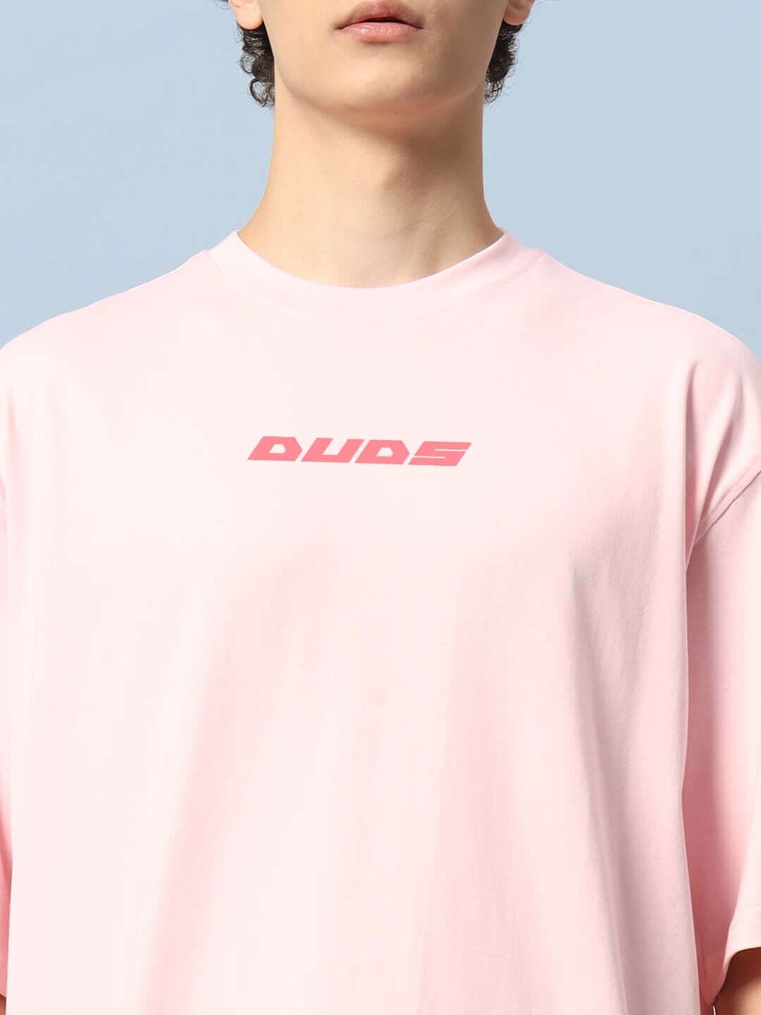 Person wearing DYING GOD OVER-SIZED T-SHIRT PINK by DUDS