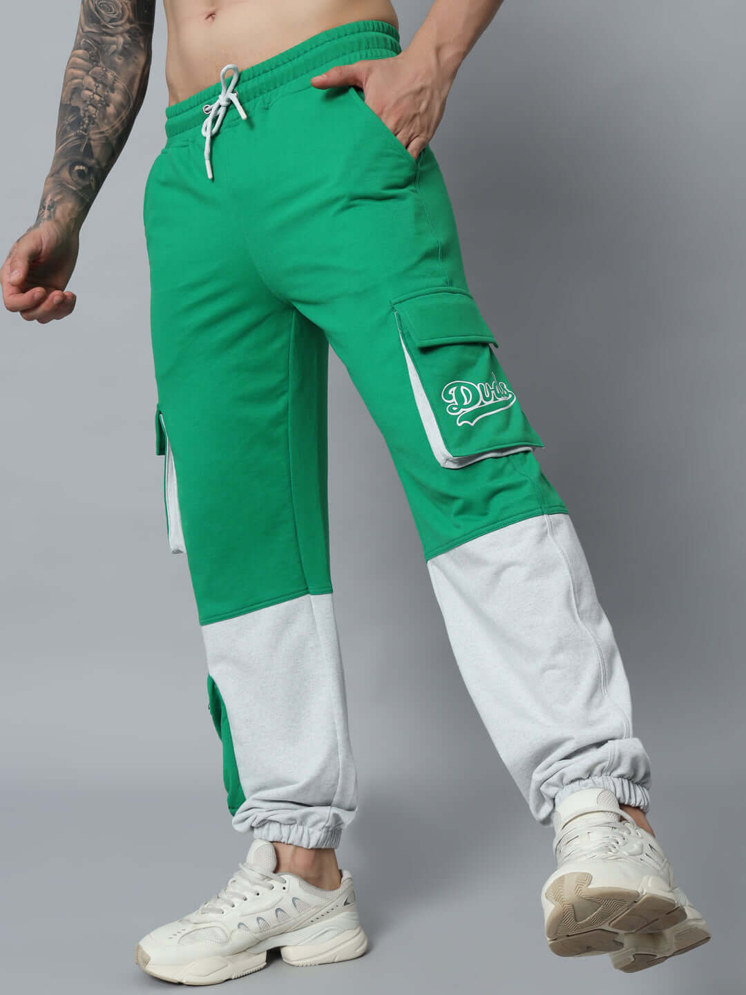 Model wearing SKYSCRAPER RELAXED FIT CARGO PANT GREEN, showcasing front pockets and ankle cuffs, made by DUDS.