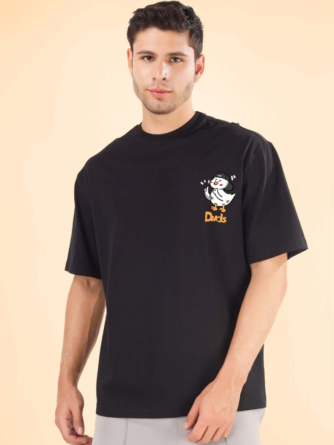 Model wearing GO MOTION OVER-SIZED T-SHIRT BLACK with DUDS logo, short sleeves, and relaxed fit, perfect for custom size option.
