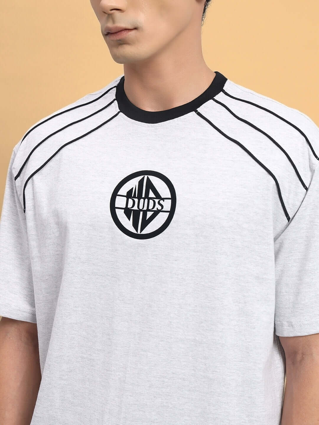 Model wearing PERCY OVER-SIZED T-SHIRT MELANGE GREY with graphic logo on front, premium cotton fabric.