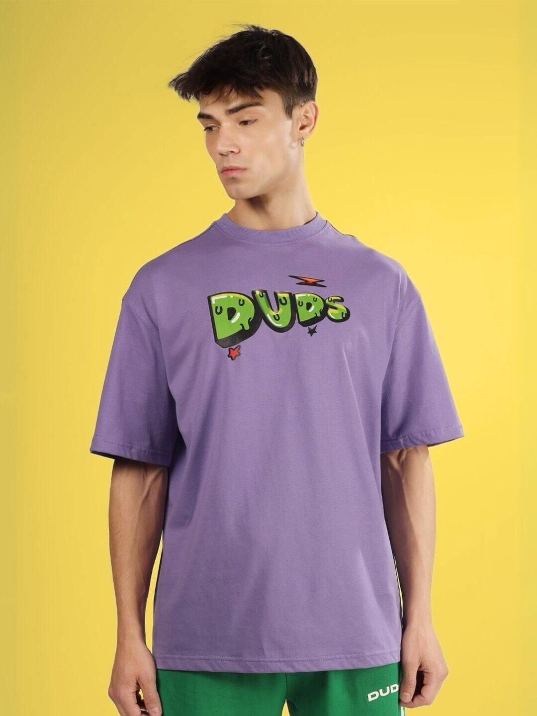 ESCAPED TWEETY OVER-SIZED T-SHIRT WISTERIA PURPLE with green "DUDS" logo, worn by model against a yellow background.