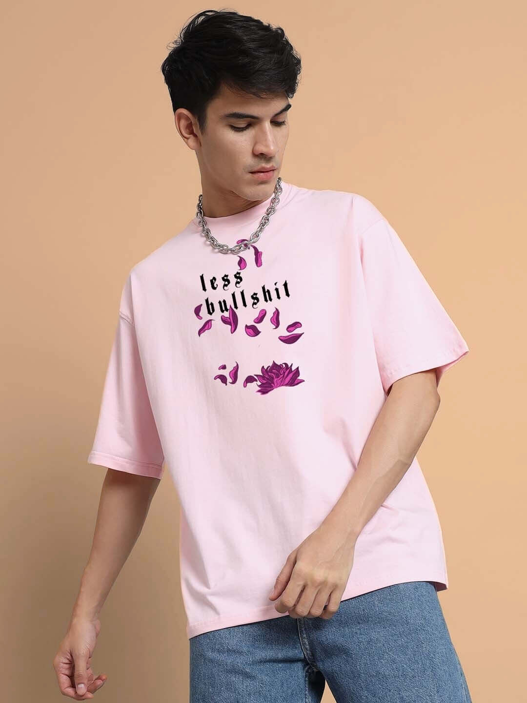 Model wearing the MOANING TIGRESS OVER-SIZED T-SHIRT PINK with graphic text, showcasing a casual streetwear style.