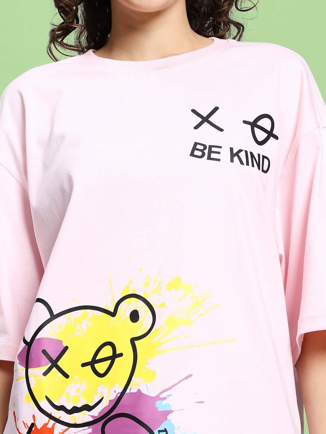Pink oversized women's T-shirt with 'Be Kind' print and colorful graphic, made from premium cotton French terry fabric.