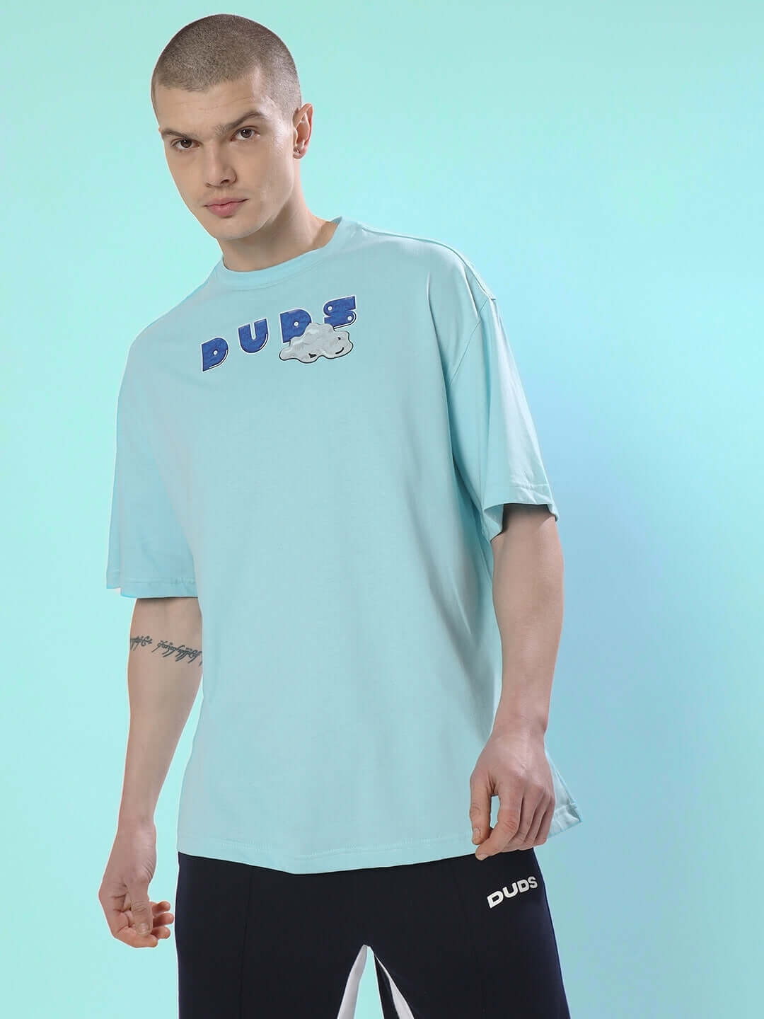 DUDS CREATIVE OVER-SIZED T-SHIRT SKY BLUE with premium heavy gauge fabric, 100% cotton, worn by a model in a stylish pose.