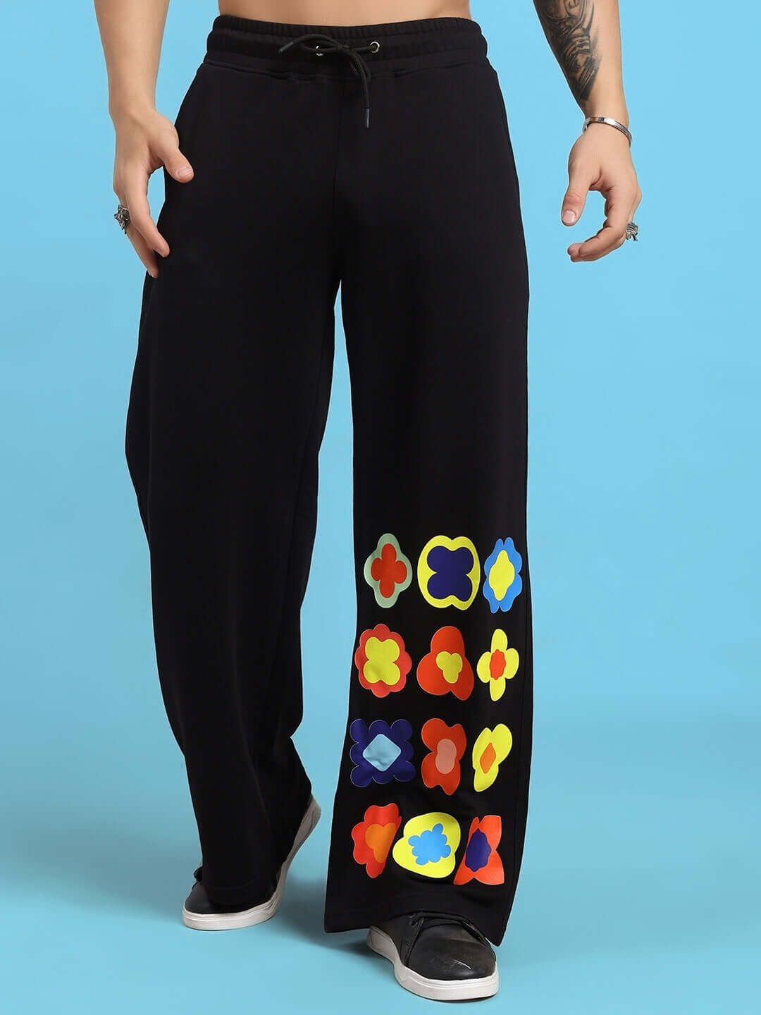 Black pants with colorful floral patterns on one leg from Hollister's tie-dye co-ord set.