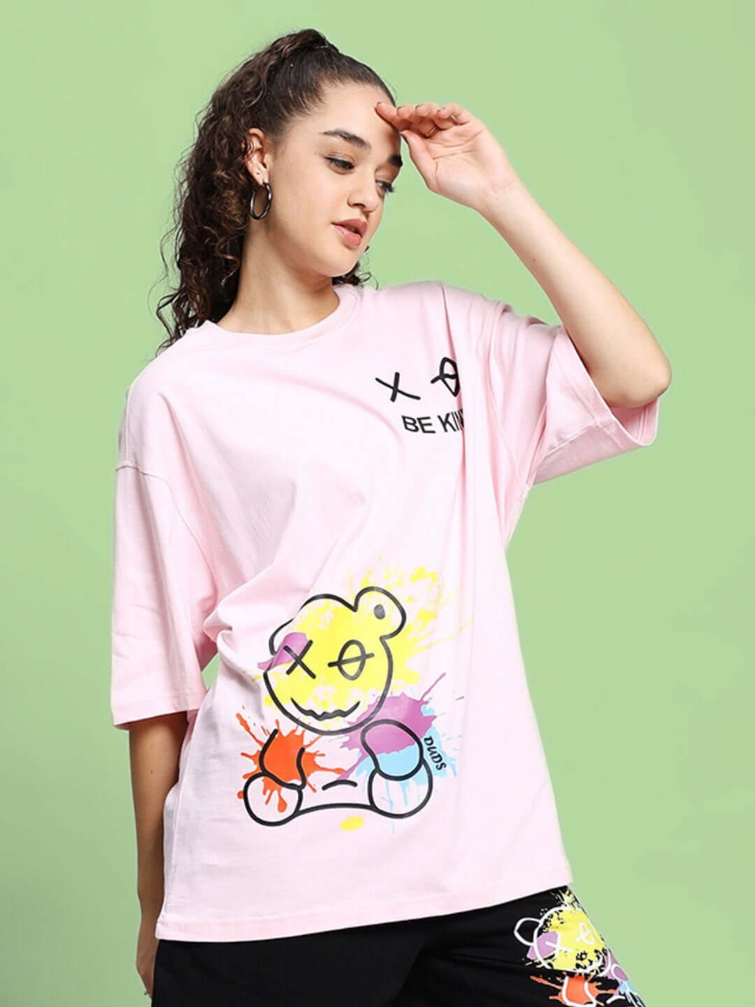 Model wearing pink oversized 'Be Kind' t-shirt with colorful graphic, made from premium heavy gauge fabric, 97% cotton, designed by Color By Colours.