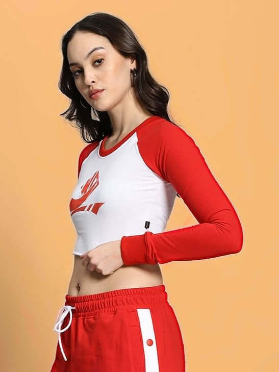 Woman wearing a red and white long sleeve crop top, styled with matching red pants.