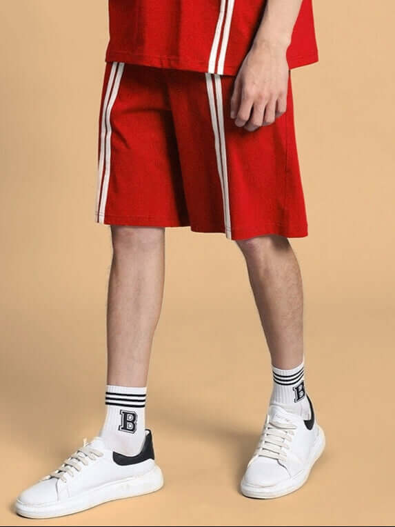Model wearing red Outlook Regular Fit Shorts with white stripes, paired with white sneakers and socks, showcasing comfortable casual style.