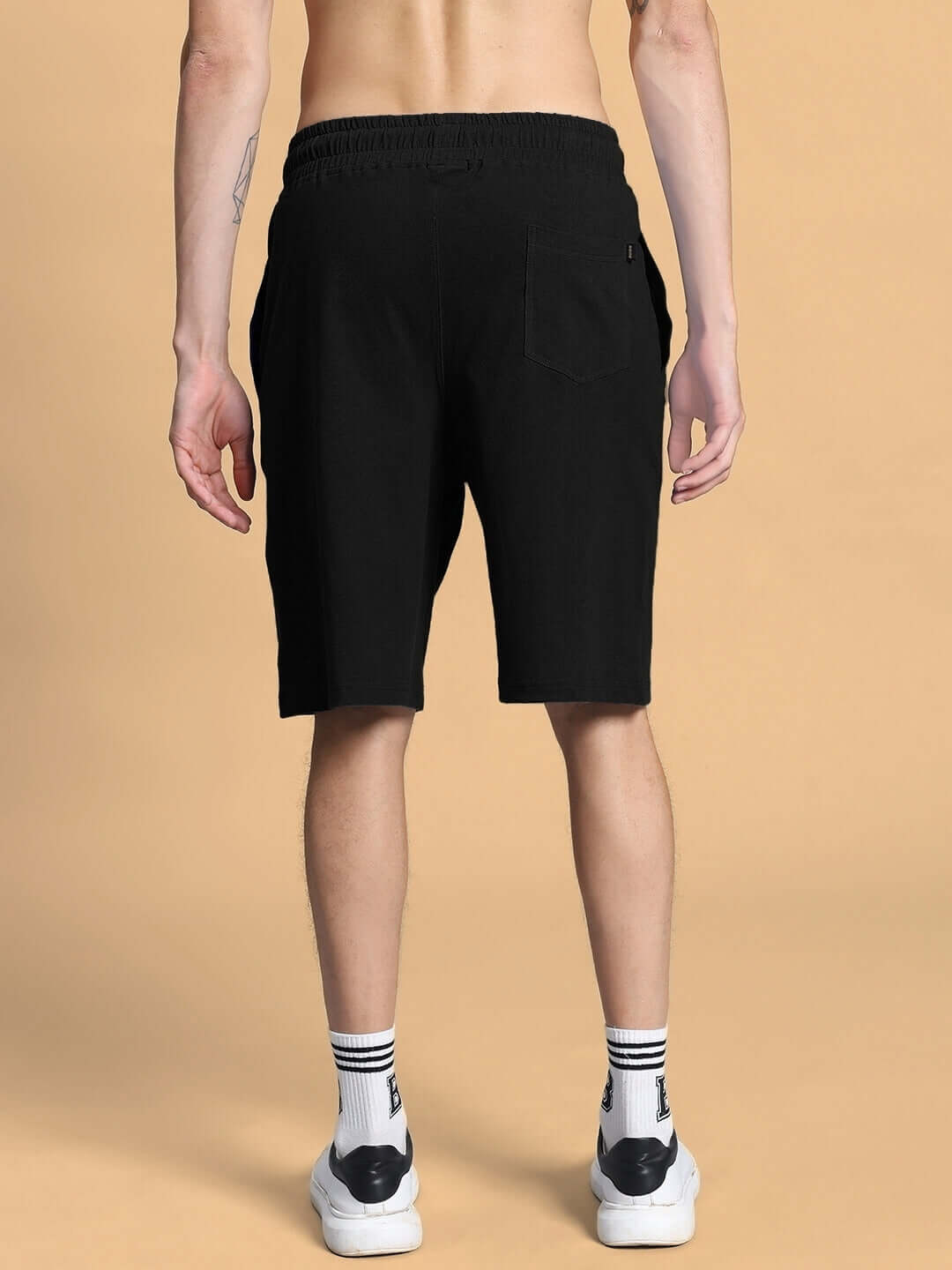 Rear view of person wearing black Outlook Regular Fit Shorts, showcasing elastic waist and relaxed fit.