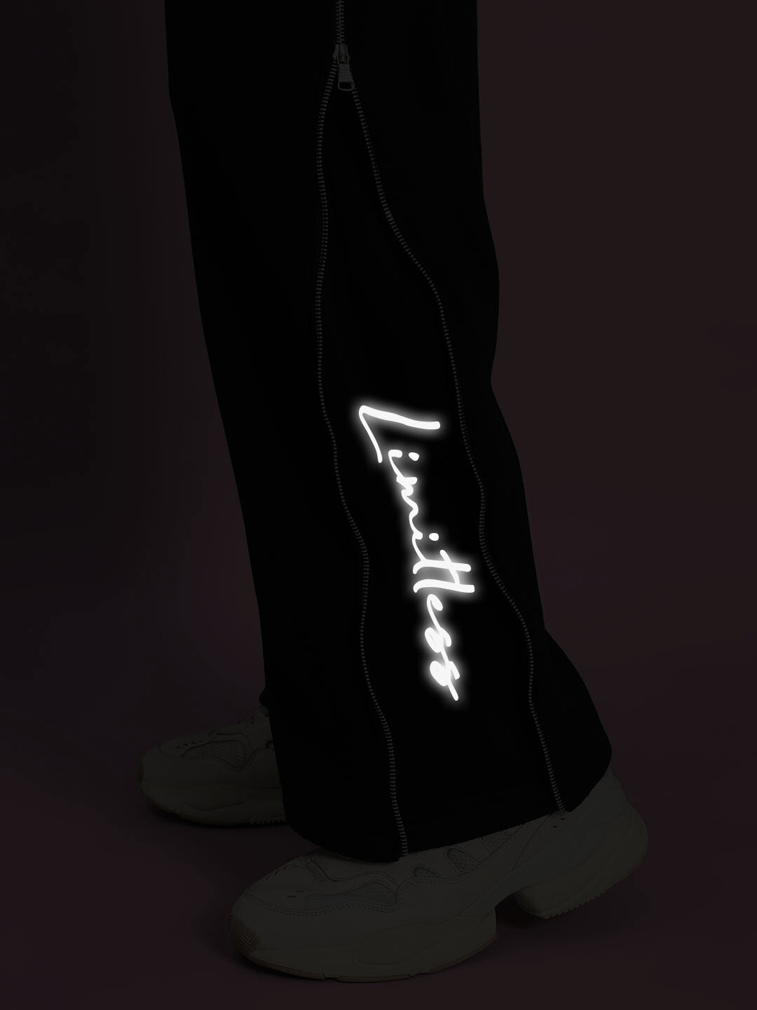Close-up of black Limitless Fleece Co-ord with reflective detail and sneakers.