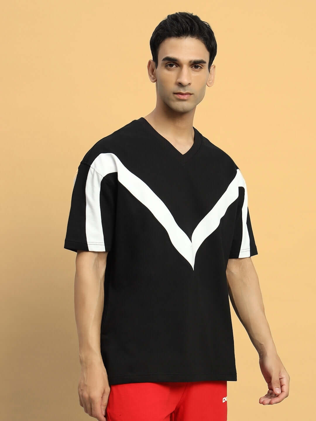 Model wearing Adroit oversized black T-shirt with premium cotton fabric, featuring white V-design, designed for comfort and style.