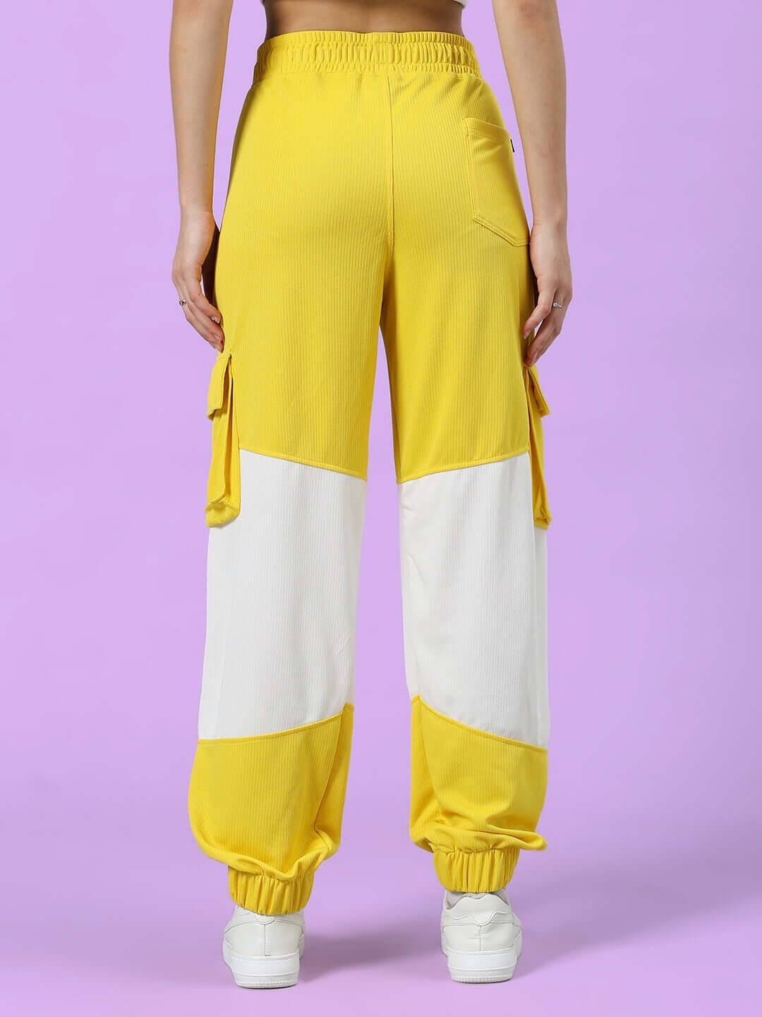 Back view of women's yellow and white relaxed fit joggers with pockets, showcasing the stylish design and comfortable elastic waistband.