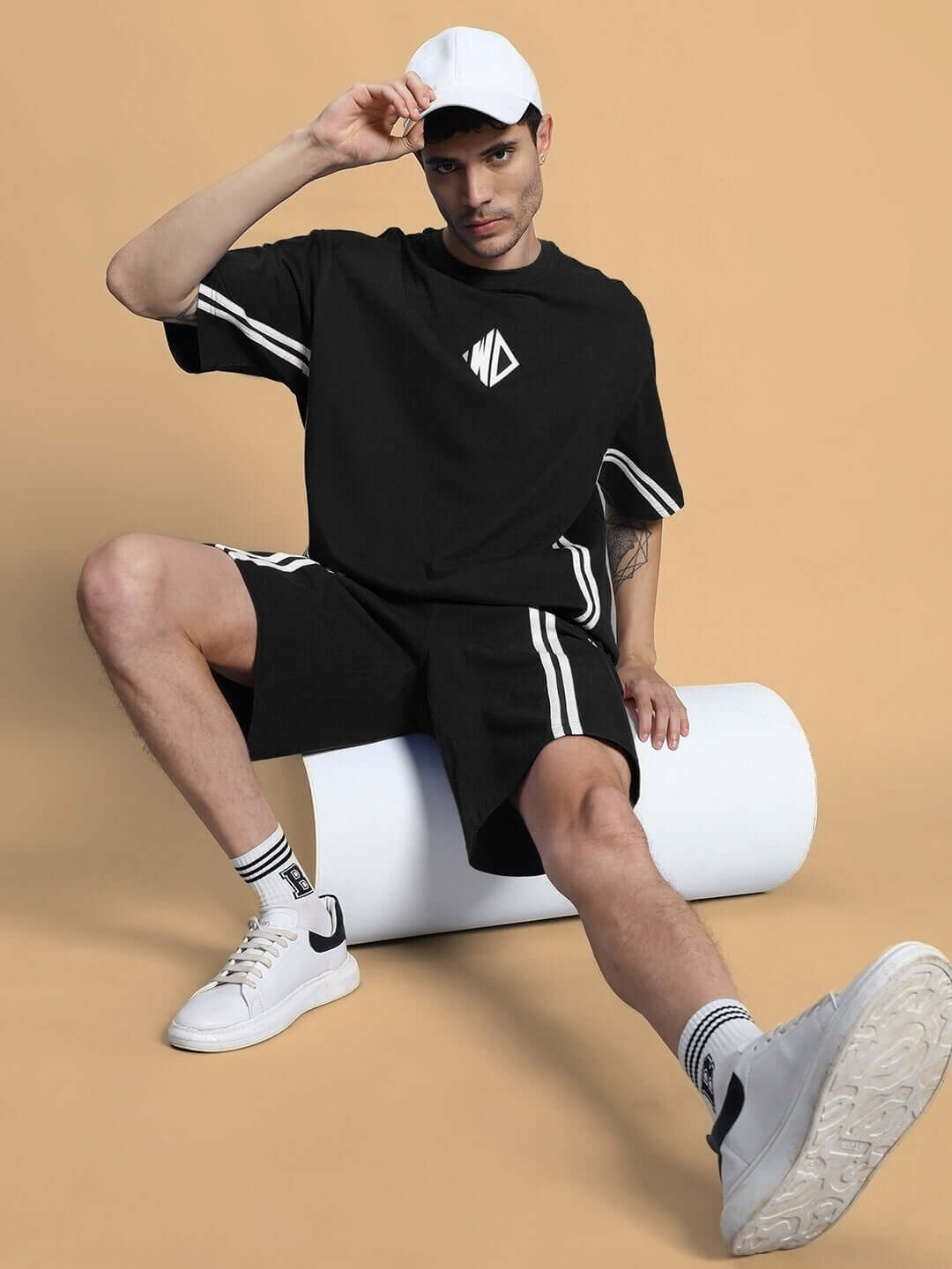 Model wearing Outlook Regular Fit Black Shorts, casual style with white cap and sneakers, showcasing comfort and custom fit options.