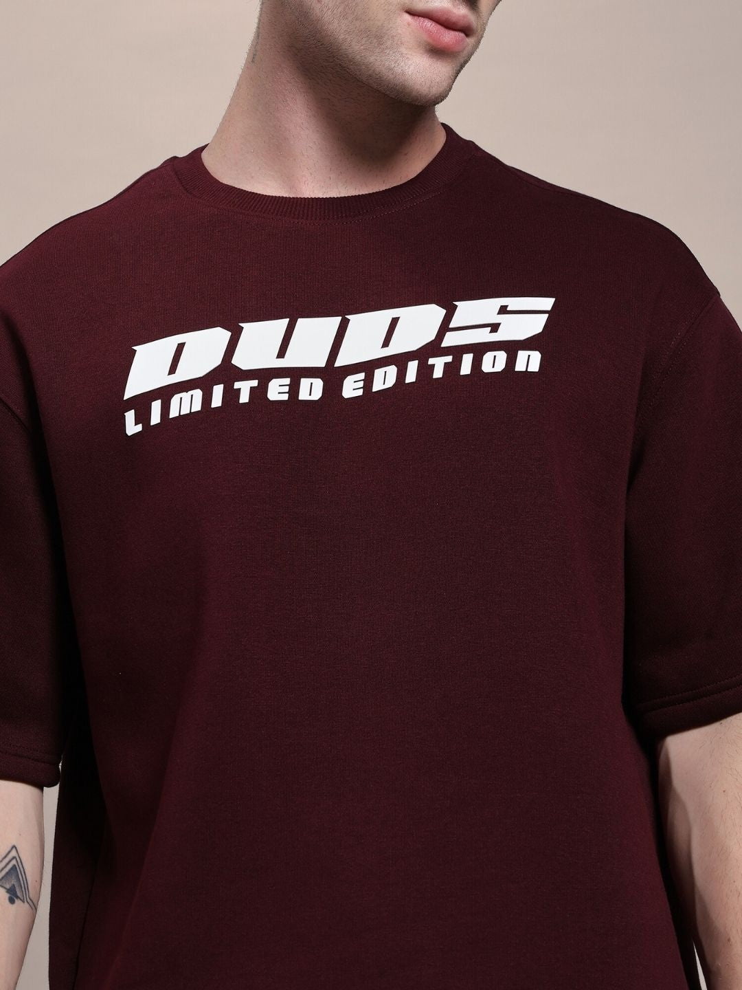 Man wearing maroon "Duds Limited Edition" shirt showing close-up design.