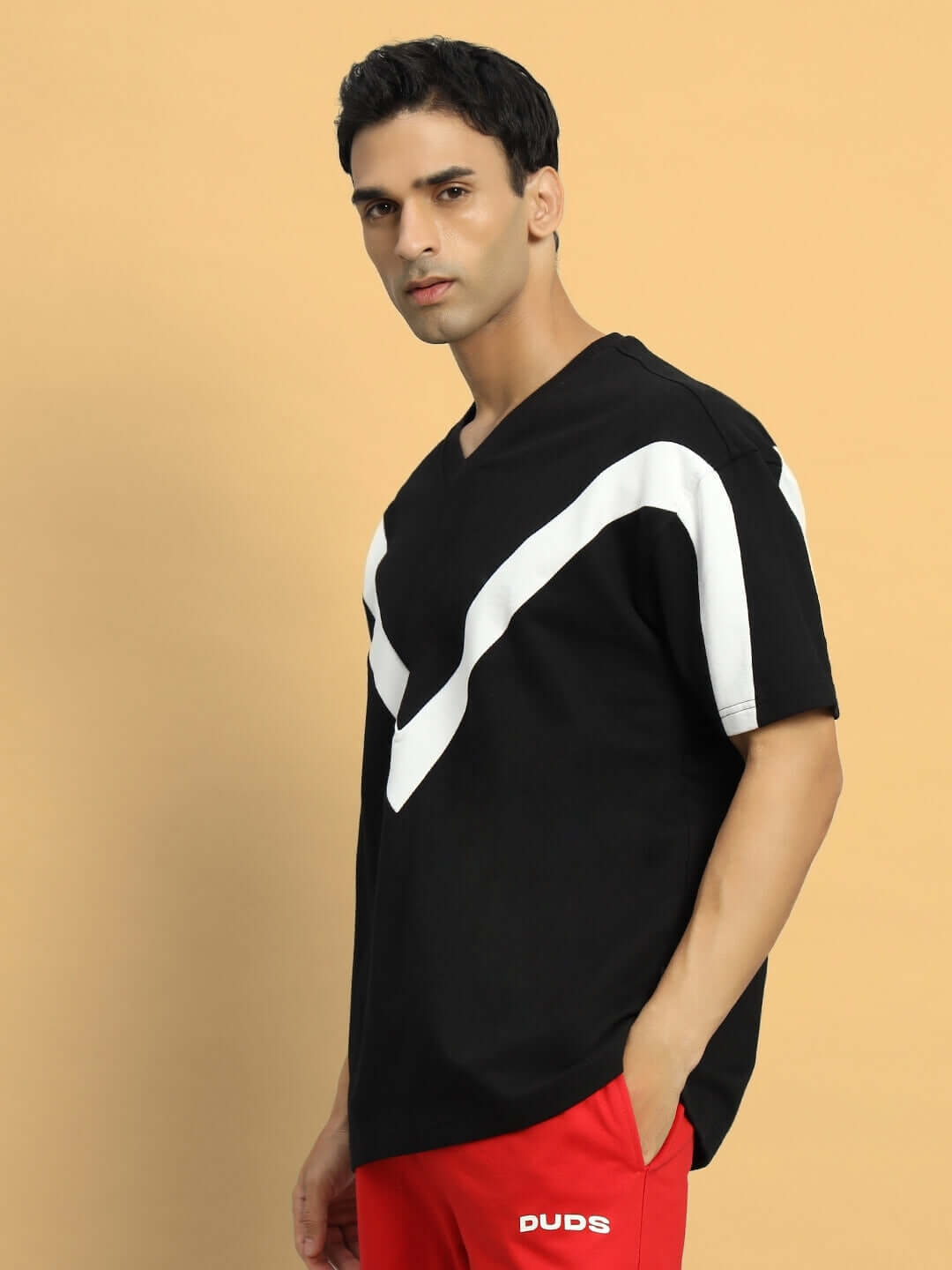 Model wearing ADROIT black oversized T-shirt, made from premium heavy gauge fabric blend, featuring stylish white stripes.