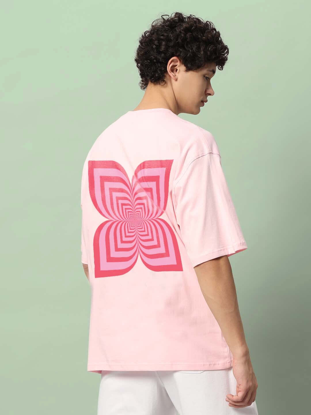Back view of pink ILLUSION OVER-SIZED T-SHIRT with geometric design, highlighting comfort and custom fit options.