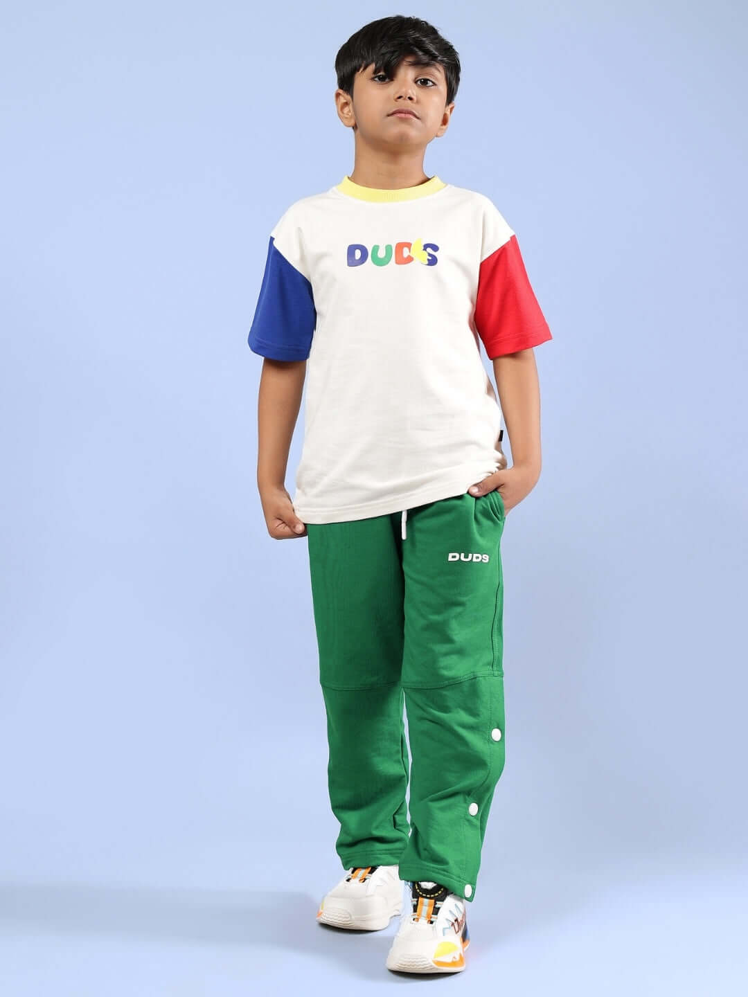 Child wearing Adonis co-ord in off white and green by DUDS with colorful sleeves, showcasing customizable and made-to-order fashion.