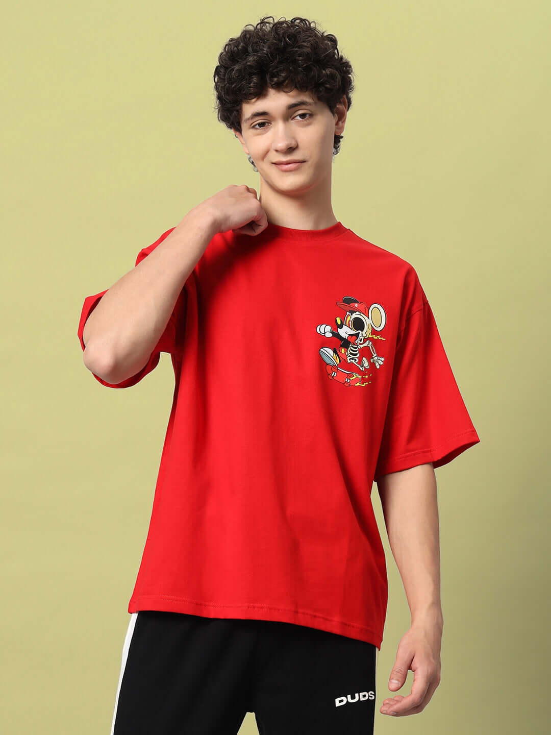 Young man wearing a red MICKEY COTTON OVER-SIZED T-SHIRT RED with a Mickey Mouse print.