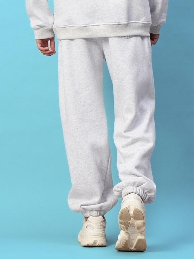 Bona-Fide Fleece Pant in Melange Grey on a model, showcasing the back view against a blue background.