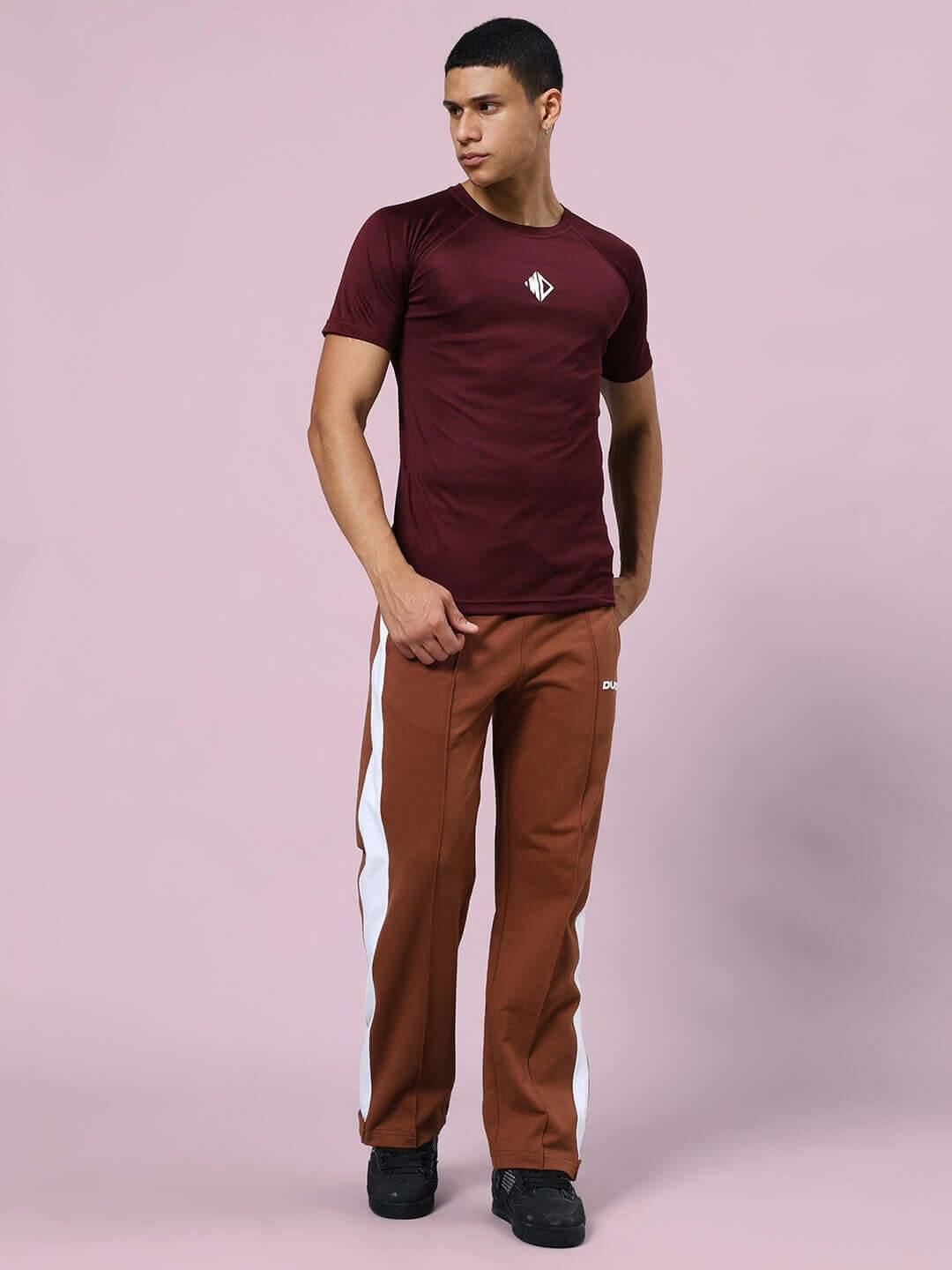 Model wearing brown Wonder Slit Zipper Joggers with white stripe, showcasing modern fit and customized size options from DUDS.