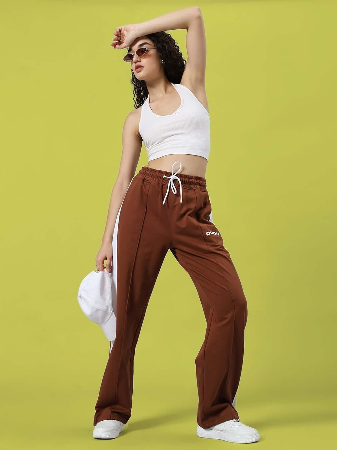 Model wearing Women's Wonder Slit Zipper Joggers in brown, paired with a white top, showcasing fashion-forward design and comfort.