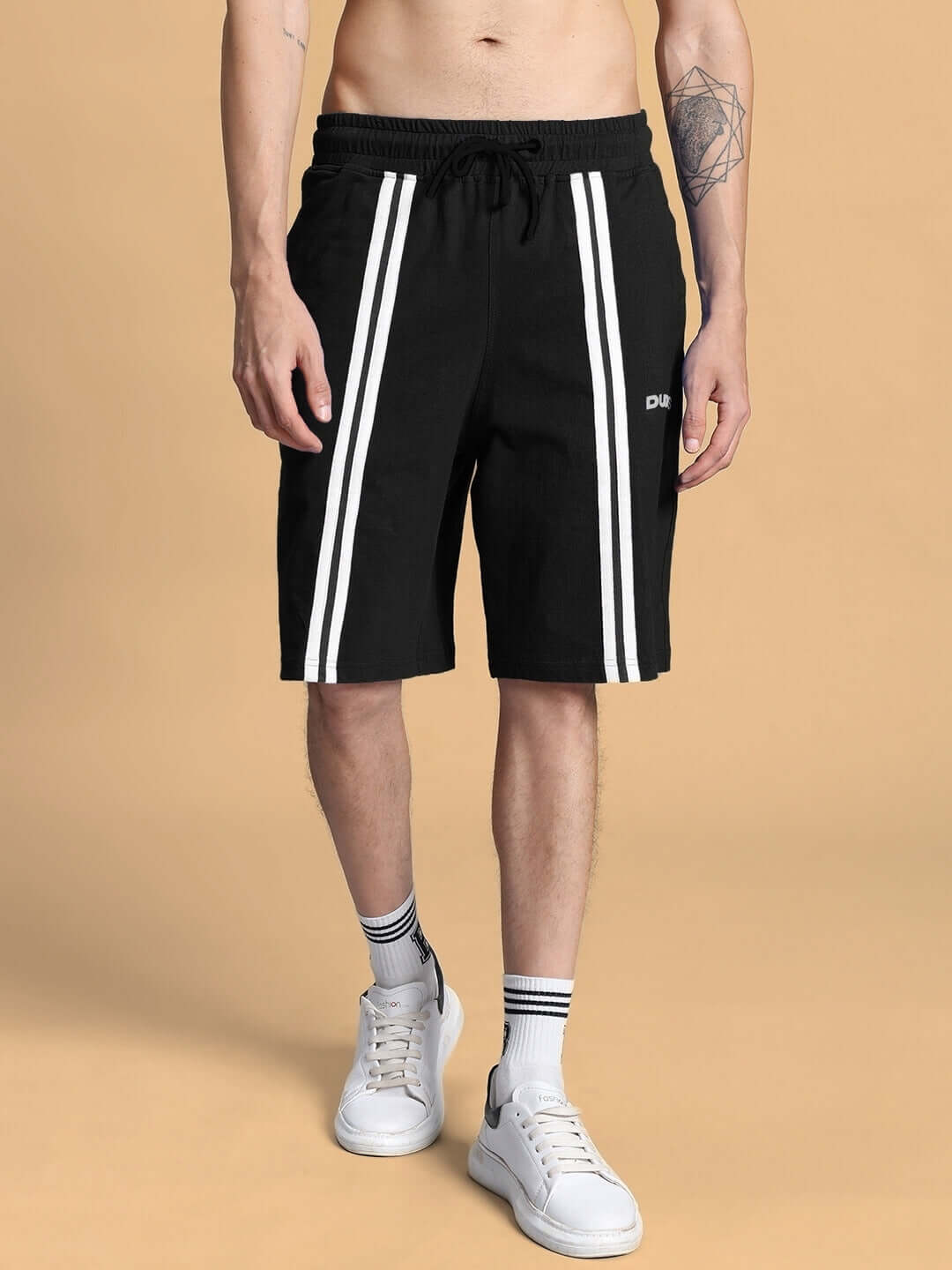 Model wearing black Outlook regular fit shorts with white stripes, showcasing athletic design and customizable size options.