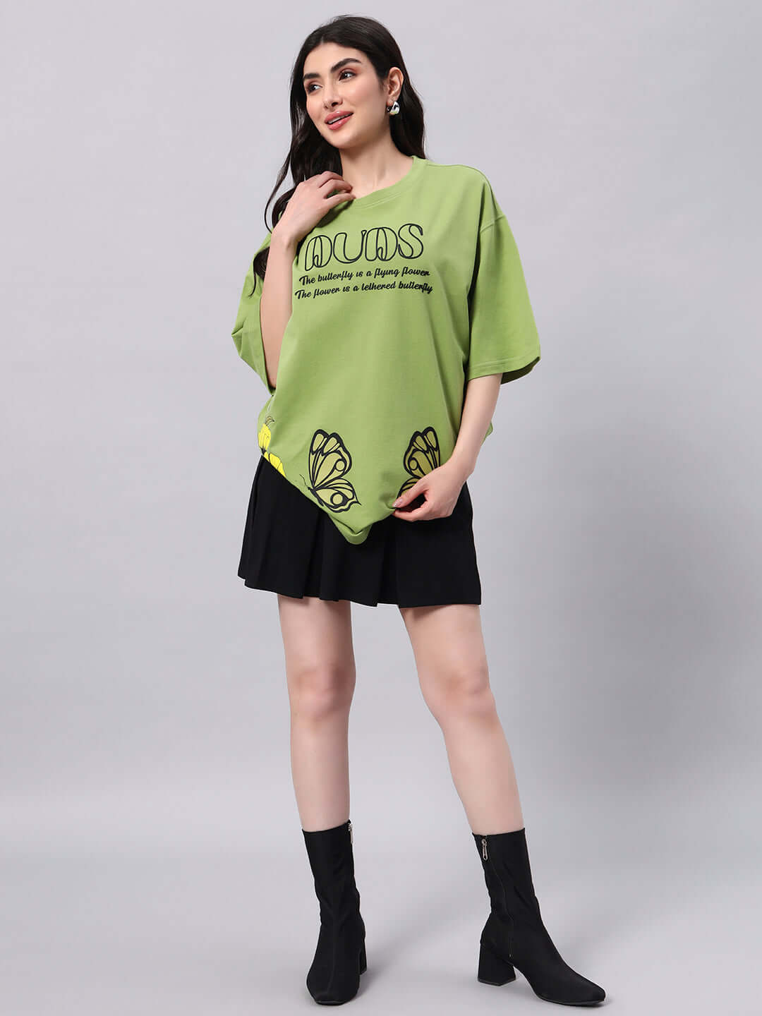 Green women's Ikon Butterfly T-shirt made from premium cotton and elastane, featuring butterfly designs, worn with a black skirt.