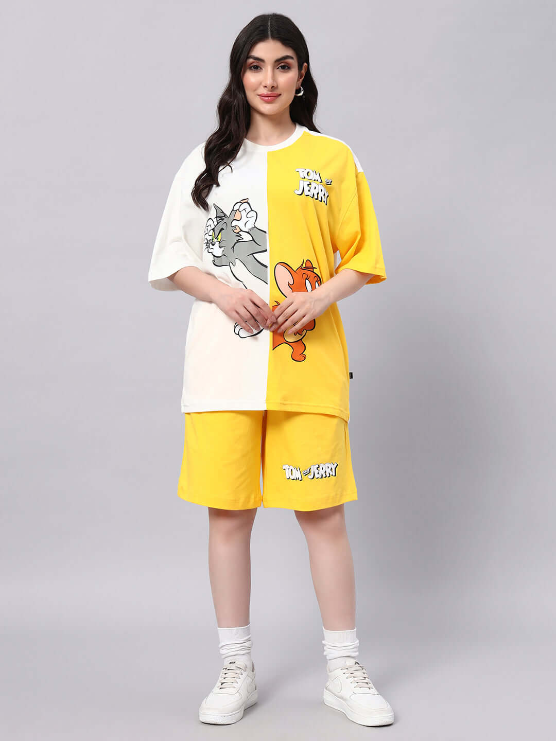 Model wearing yellow Tom & Jerry summer shorts set, featuring cartoon prints, perfect for casual wear.