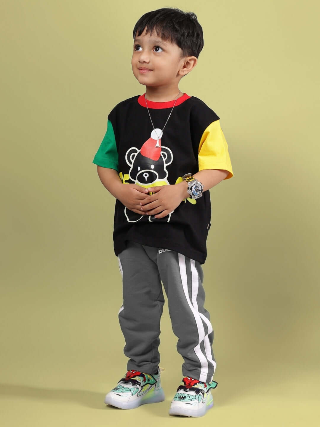 Child wearing a DUDS mocha co-ord in black and grey with colorful accents, featuring a playful bear graphic, suitable for boys and girls.