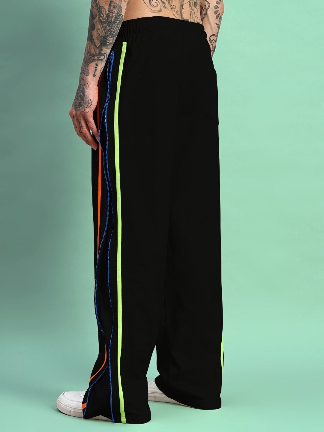 Side view of person wearing Imperial Side Zipper Joggers in black with colorful side stripes, featuring a casual fit style.