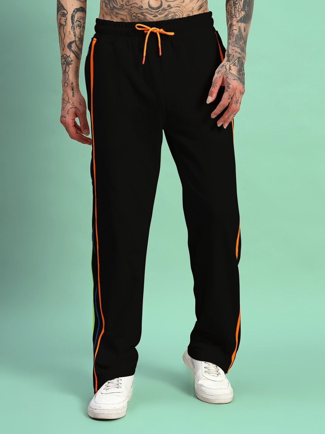 Model wearing Imperial Side Zipper Joggers in black with rainbow stripe detailing and white sneakers.