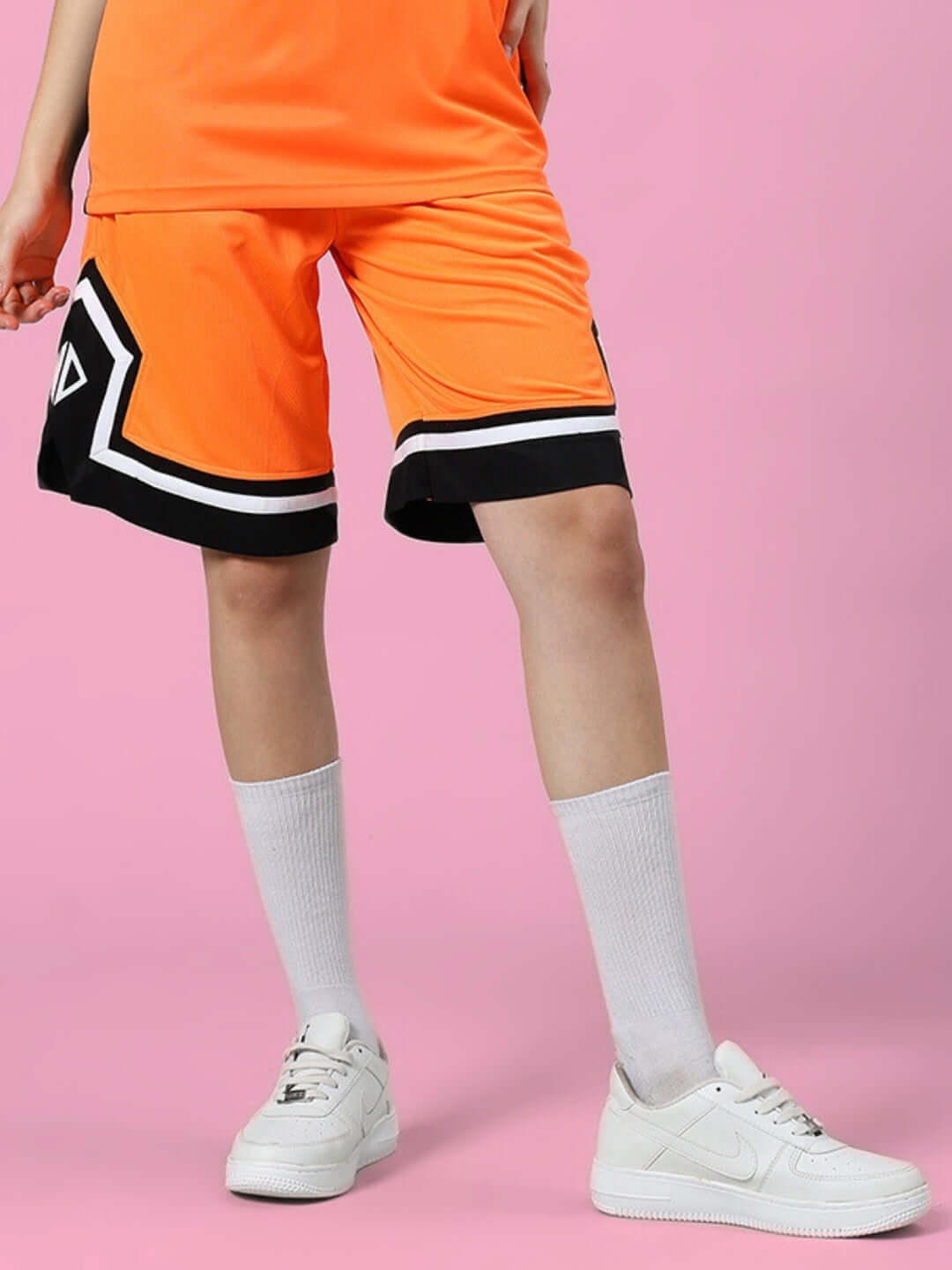 Women's Armado regular fit shorts in orange and black, shown on a model with white sneakers, perfect for casual wear and sporty look.