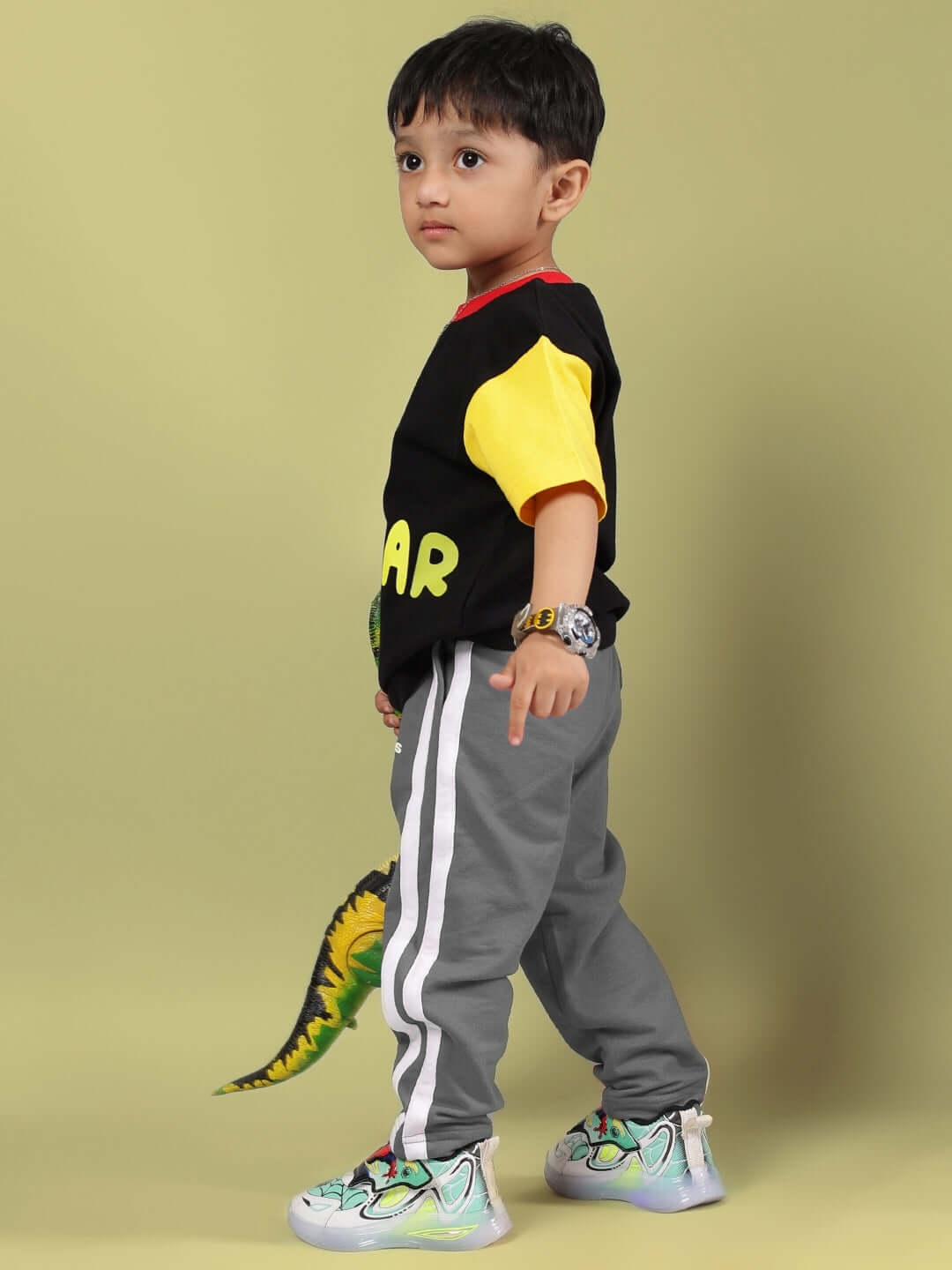 Child wearing black and grey MOCHA co-ord set for boys and girls featuring colorful dinosaur design and sporty stripes.