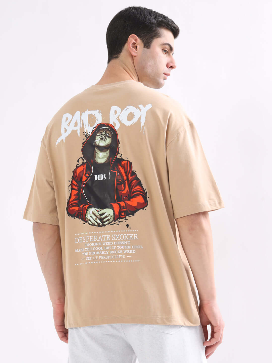 Back view of model in BAD BOY OVER-SIZED T-SHIRT NUDE, featuring graphic print on premium 100% cotton fabric, bio-washed for softness.