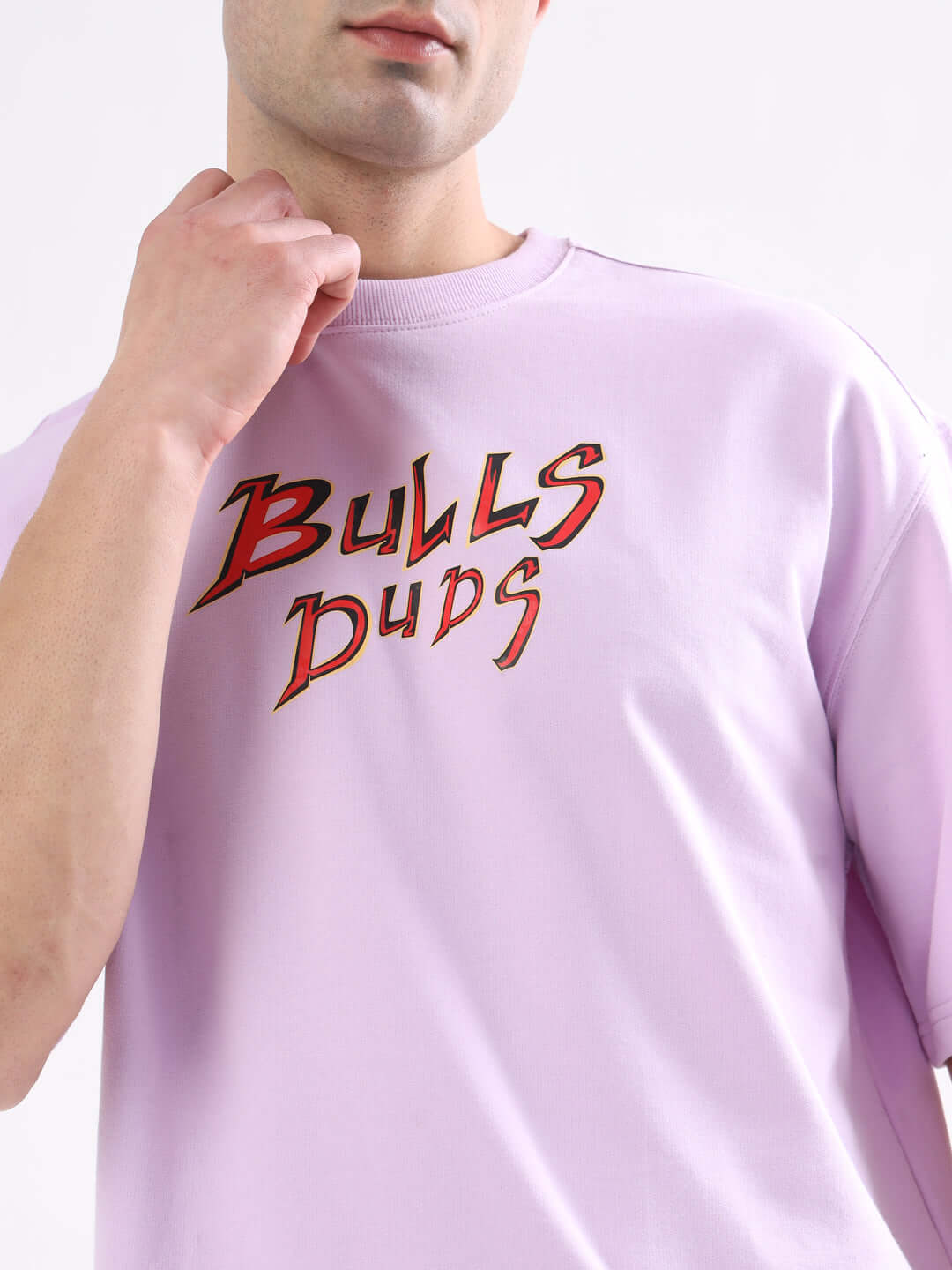 Person wearing WILD BULL OVER-SIZED T-SHIRT LAVENDER with bold lettering, showcasing premium cotton fabric in a trendy lavender shade.