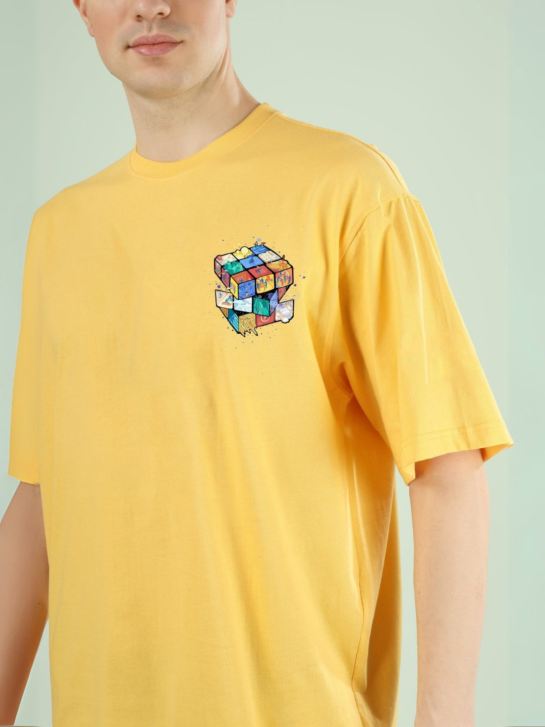 RUBIK REVOLUTION OVERSIZED T-SHIRT YELLOW featuring a colorful Rubik's cube design on the chest, showcased on a model.