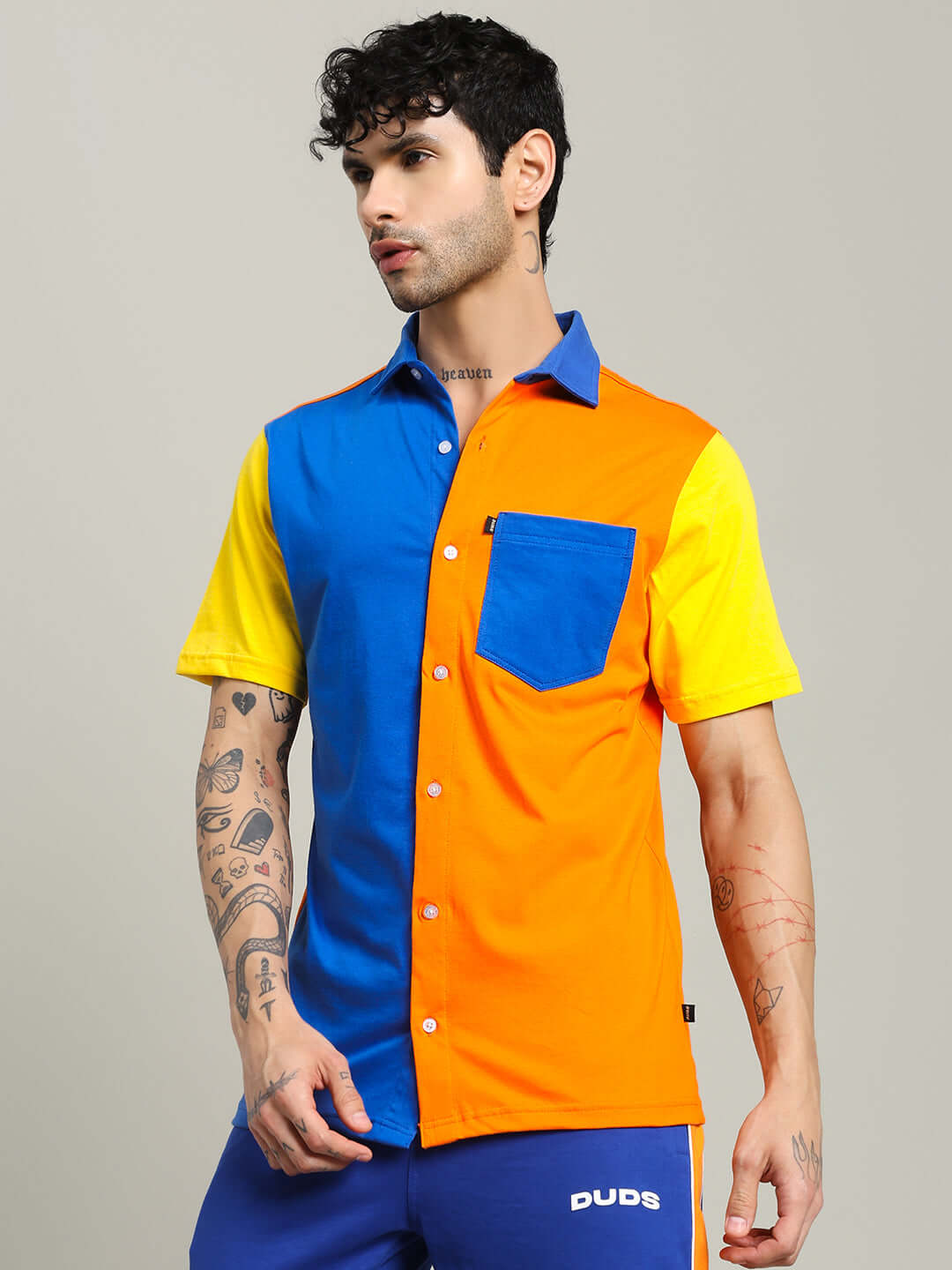 Man wearing APEX Regular Fit Shirt in multi orange with blue and yellow panels, featuring short sleeves and a chest pocket.