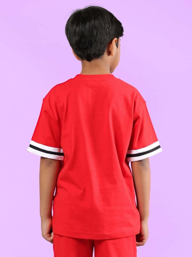 Child wearing DIGGIN red oversized t-shirt for boys & girls with striped sleeves, standing against a purple background.
