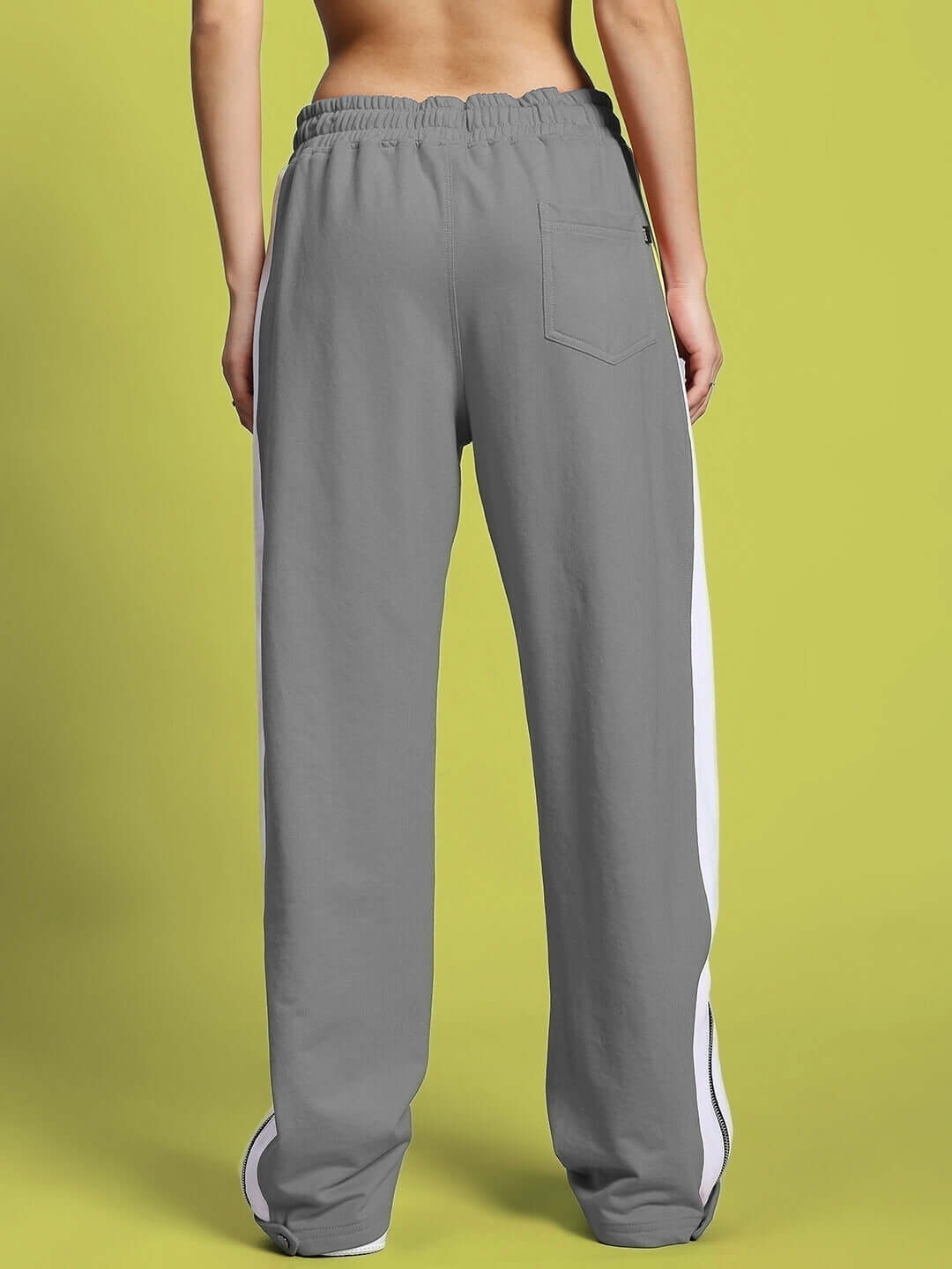 Rear view of grey-white Women's Wonder Slit Zipper Joggers with elastic waist and stylish side stripes.