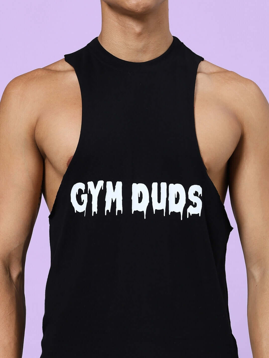 Man wearing black sleeveless top with 'Gym Duds' text on front, showcasing casual workout apparel style.
