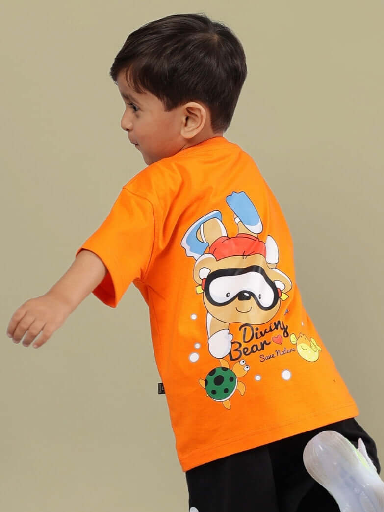 Young boy wearing orange Diving Bear t-shirt, featuring a cartoon bear with diving gear. Perfect for kids. Made by DUDS.