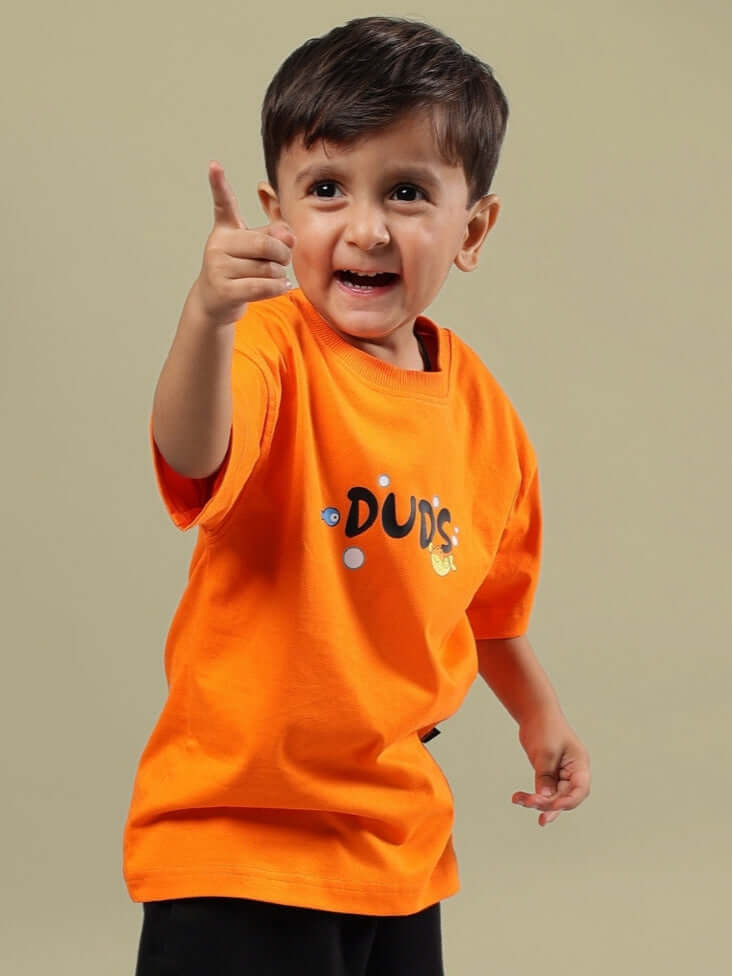 Child wearing orange "Diving Bear" T-shirt from DUDS, made for boys and girls, with customizable options available.