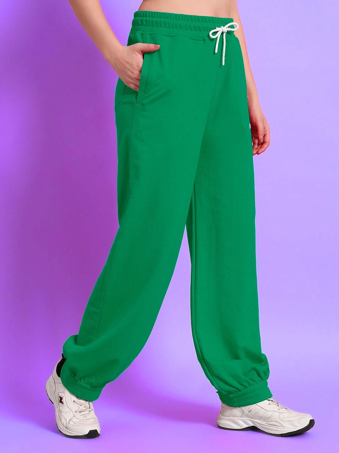 Woman wearing green relaxed-fit joggers with elastic waistband and pockets, showcasing casual style and comfort.