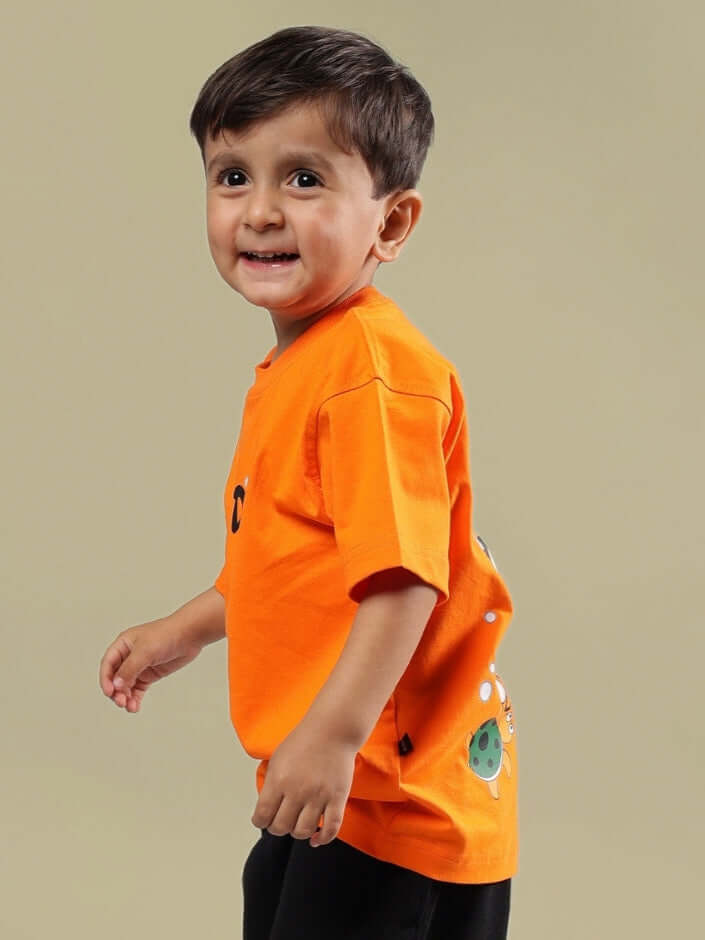 Smiling child wearing an orange Diving Bear t-shirt, perfect for boys and girls; customizable sizing available, tailored by DUDS.