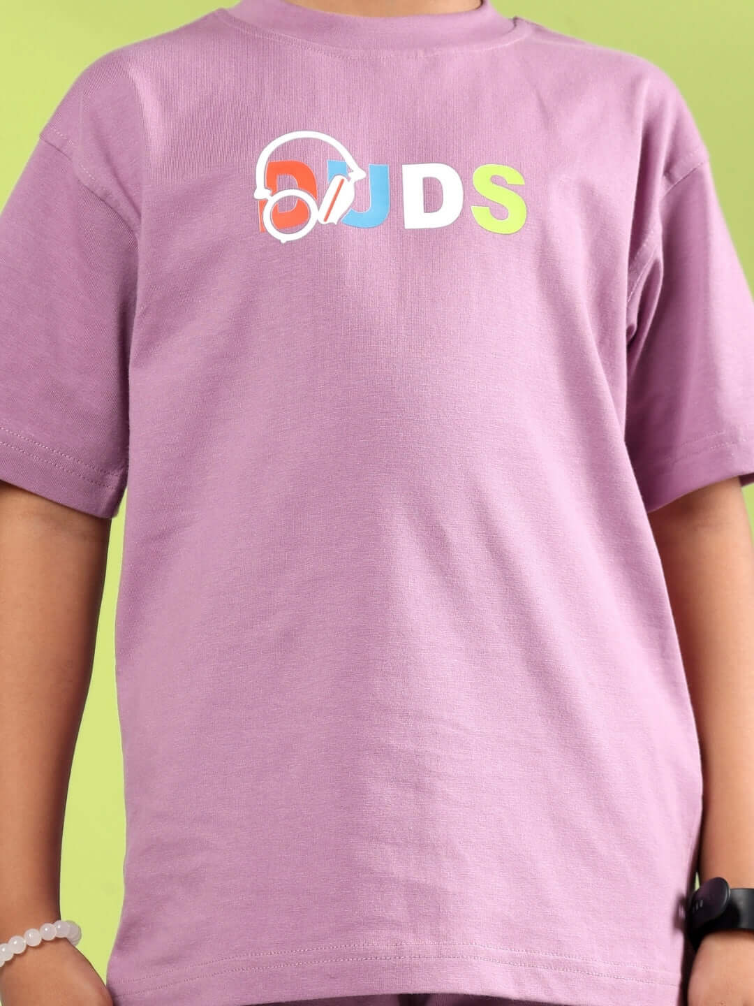 Child wearing STOIC t-shirt in Pulm Purple, featuring DUDS logo, suitable for boys and girls. Made to order with custom fit option.