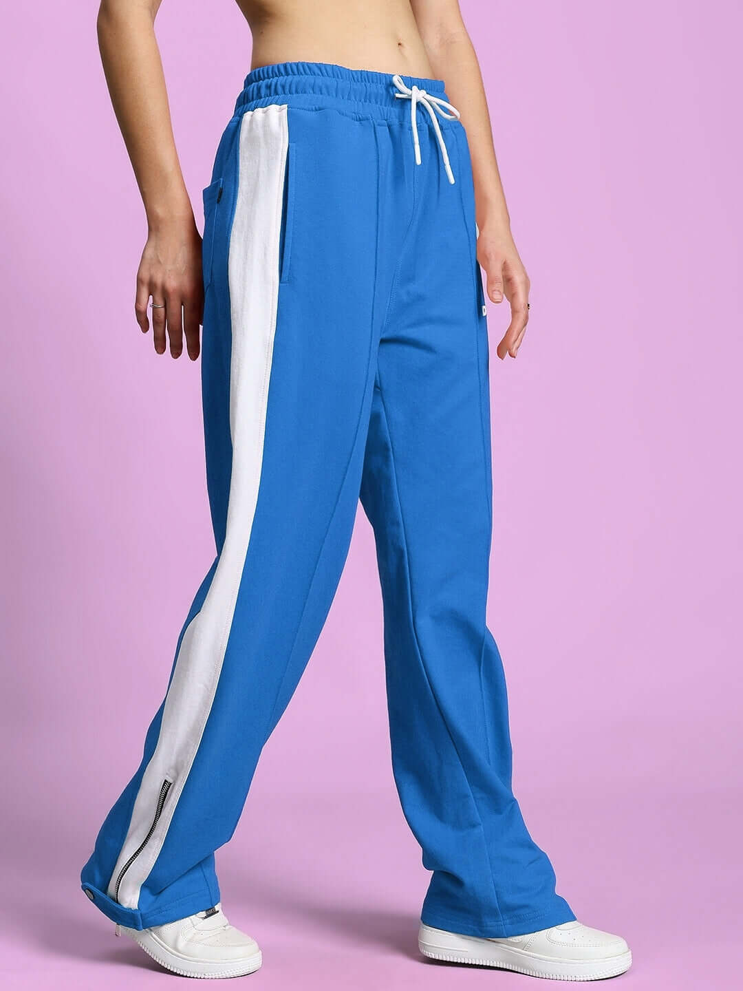 Model wearing Women's Wonder Slit Zipper Joggers in blue-white with customizable fit options, made by DUDS, shown with white sneakers.
