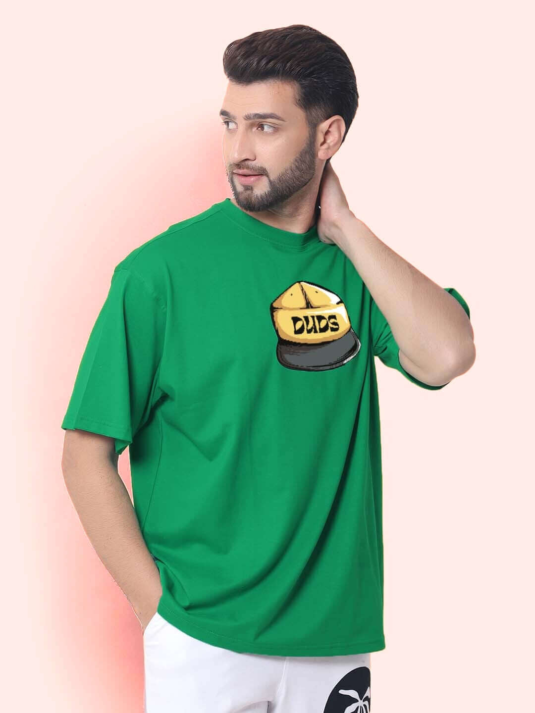 Man wearing HIGH-ON OVER-SIZED T-SHIRT GREEN with DUDS logo, available with customizable fit for prepaid orders.