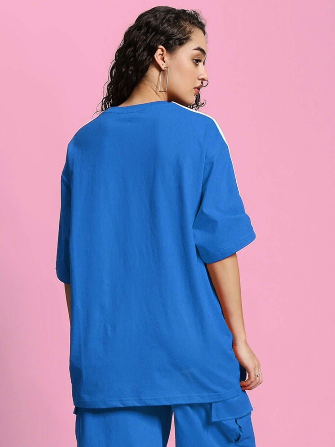 Back view of a woman wearing an oversized blue t-shirt made of premium cotton, perfect for casual wear.