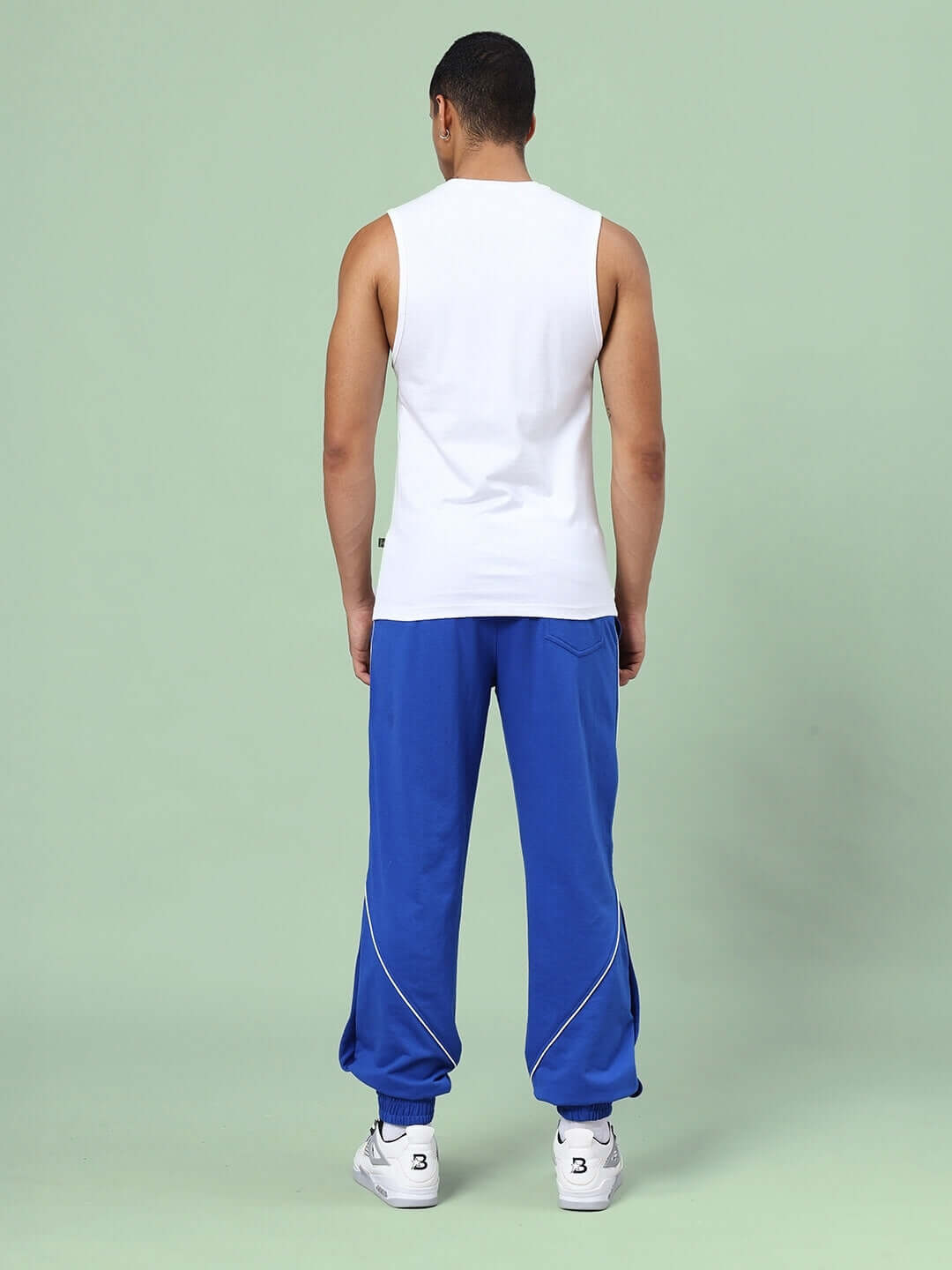Model wearing Kickshaw relaxed fit co-ord set in white and royal blue, showcasing the unisex joggers with elasticated waistband.