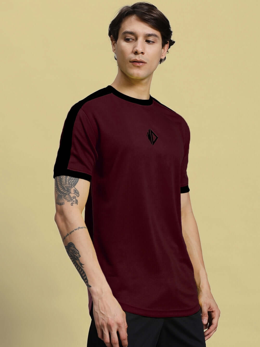 Model wearing SHERPA Regular Fit T-Shirt in maroon with black accents, made of sports polyester fabric, showcased from the front view.